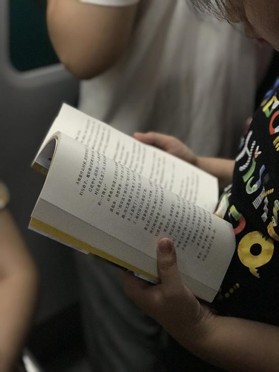 　　下车前看到小朋友在读《青铜葵花》，她肩上还背着琴。放暑假了，地铁上的孩子多了起来，而孩子多会带本书上地铁。