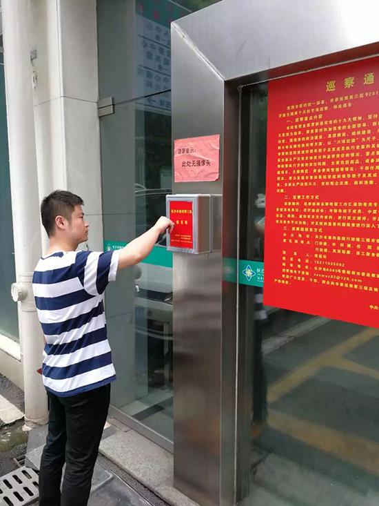 巡察组工作人员在收取意见箱内的举报信件,举报箱上张贴着“此处无摄像头”的提示