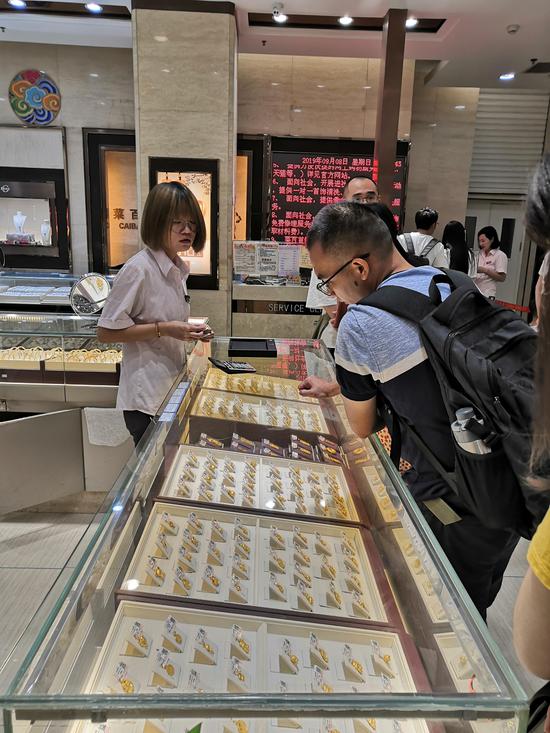 金价上涨,菜市口百货商场金饰柜台吸引了不少顾客流连忘返。 新京报记者 张姝欣 摄