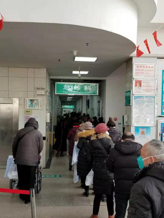 1月30日中午，武汉第六医院，发热患者排着长队等待就医。
