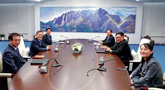 4月27日,韩国总统文在寅(左二)和朝鲜国务委员会委员长金正恩(右二)在板门店举行会晤。右一为金与正。图/韩朝首脑会晤媒体报道团