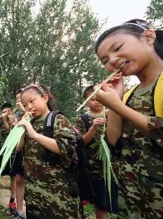 （资料图片）山东省烟台市昆嵛山的一个野外生存夏令营，营员们正在从植物中摄取水分。图/视觉中国