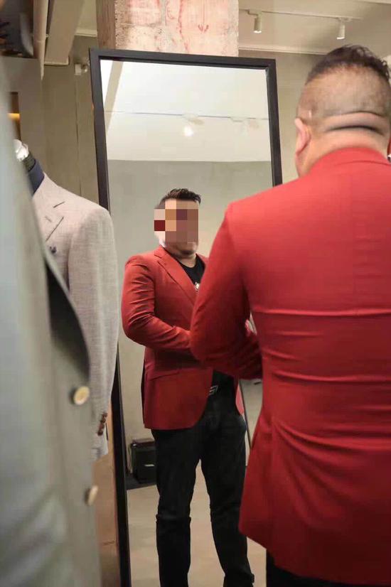 ▲孙小果在昆明一家定制西装店试装,拍摄时间2018年。图片来源:新京报网
