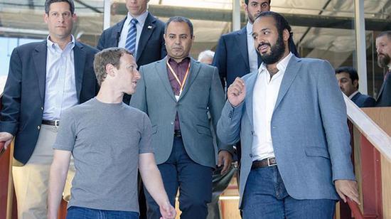 默罕默德（右一）身着西装与脸书CEO扎克伯格（前左）交谈。