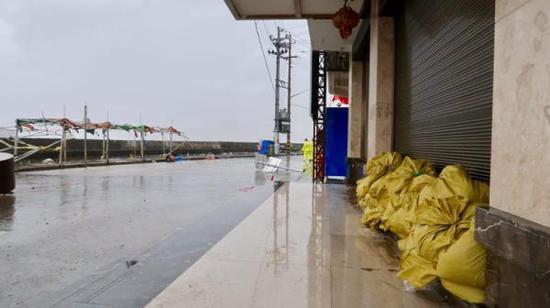 居民在大门口堆沙包，防止海水倒灌。澎湃新闻记者 杨亚东 摄