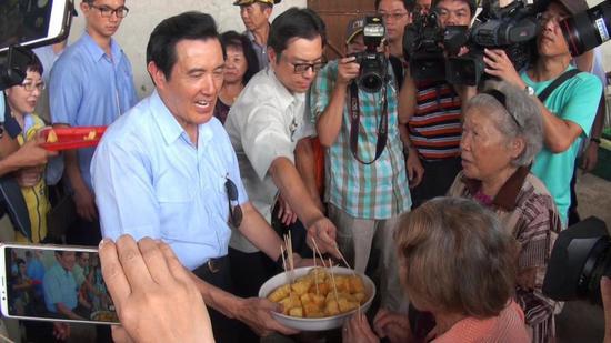 马英九向在场的人推销凤梨(图源:台媒)