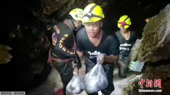 图为营救人员在往溶洞内运送救援所需的物资。