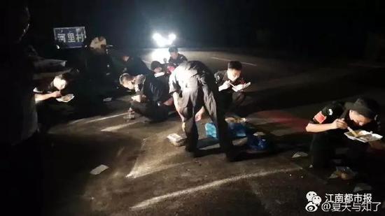 (深夜,公安干警们蹲坐在地上吃盒饭)