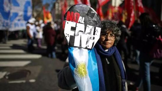 ▲一名阿根廷民众抗议政府与国际货币基金组织签订贷款协议。（法新社）