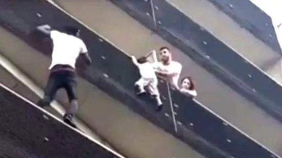 ▲加萨马徒手攀登上了四层楼高的公寓，救下了一名悬在阳台外的男童。