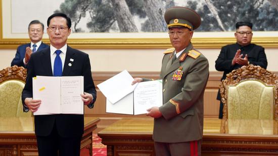 9月19日，在金正恩和文在寅见证下，朝韩防长签署军事协议。（韩国SBS新闻）
