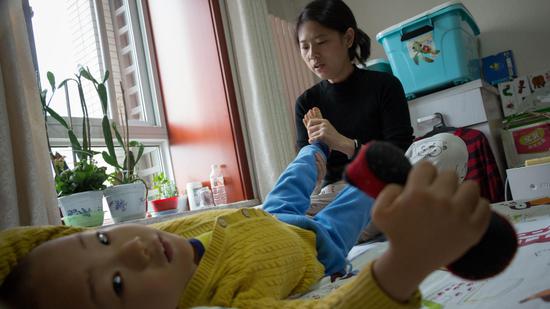 △  2018年10月15日，北京市通州区，松子妈妈给松子做脚部按摩，因为血液不流通，松子的脚常年冰凉