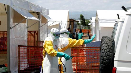 ▲身穿防护服的卫生工作者在刚果民主共和国的埃博拉治疗中心对救护车进行消毒。（图片来源：路透社）