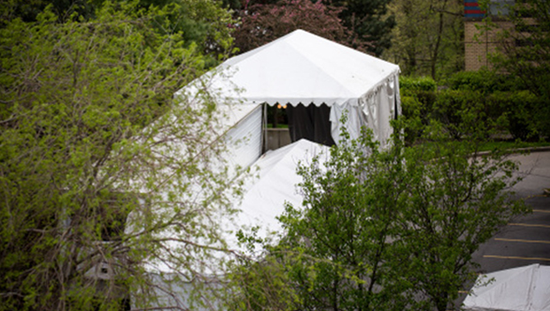 5月3日，一辆用作临时停尸房的冷藏车停在美国纽约伊莎贝拉老年中心内。新华社 图