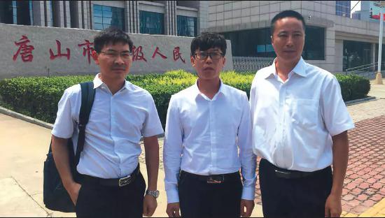 ▲8月9日,河北省唐山中级人民法院宣判廖海军无罪后,廖海军与两名律师在高院门口合影。