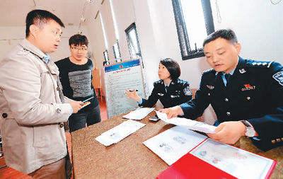 3月29日,西安市公安局高新分局高新路派出所户籍民警在户籍新政宣传活动上现场受理落户需求。新华社记者 李一博摄