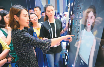 在2018中国国际大数据产业博览会上,参观者通过阿里巴巴的虚拟试衣镜体验现场试衣。 新华社记者 欧东衢摄