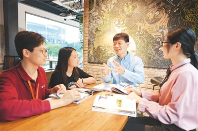 2018年10月23日,来福建福州创业的台湾青年李儒钦(右二)在福州市台湾青年创业就业基地“索佳艺”众创空间与两岸青年交流。 新华社记者 林善传摄