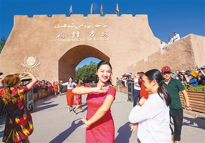 在新疆喀什古城景区开城仪式上，游客们翩翩起舞。 新华社记者 赵 戈摄