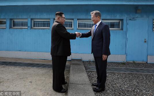 今年4月，朝鲜最高领导人金正恩和韩国总统文在寅在军事分界线握手。（视觉中国）