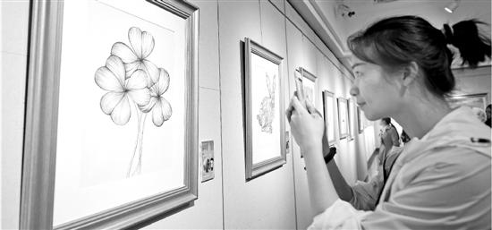 4月2日,杭州举办“来自星星的画语”特殊学生公益画展。观众在拍摄自闭症学生创作的画作。 新华社发