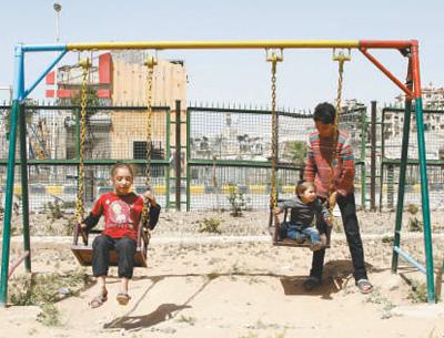 今年4月20日，在叙利亚首都大马士革东郊杜马镇，几名孩子在废弃的公园里荡秋千。 　　新华社发