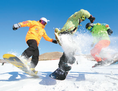 在内蒙古兴安盟突泉县宝石滑雪场，三位单板滑雪爱好者正尽情玩耍。康毕力格 摄