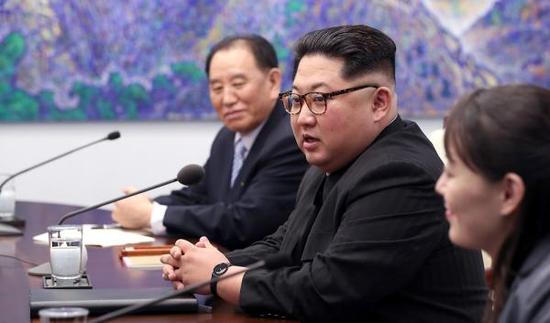 朝鲜最高领导人金正恩身穿富有朝鲜特色的黑色“人民装”,戴着一副富有时尚气息的豹纹眼镜。