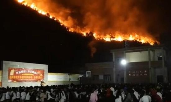 网传“学校山火旁淡定开会”视频。 截屏图