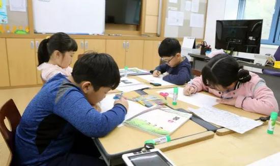 4月24日,学生在韩国大成洞村大成洞小学画画。 新华社记者李鹏摄