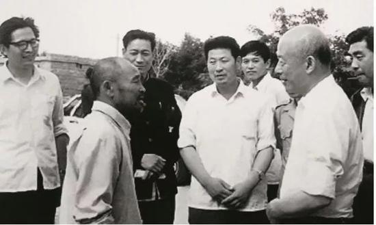林乎加(前右)在调研期间与当地农民交流