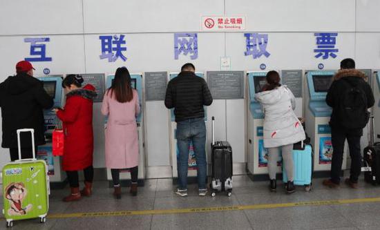 旅客在互联网取票区取火车票。 东方IC 资料图