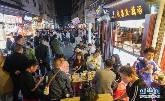3月28日,人们在武汉市闻名的小吃街户部巷休闲消耗。新华社记者 程敏 摄