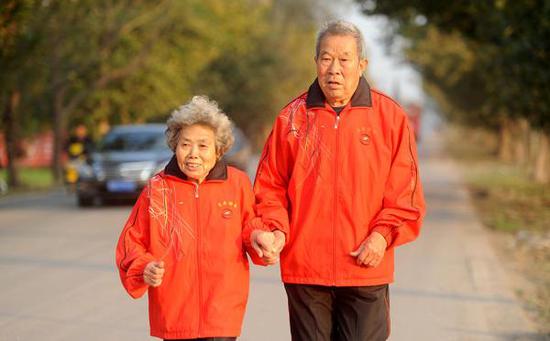 2014年11月6日，安徽淮南，中国马拉松赛的第一个纪录创造者张亮友与老伴尚殿娥一起长跑，享受健康人生。 视觉中国 资料图