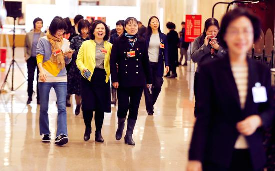 在市政协十三届三次会议委员驻地通往小组会场的走廊上,委员们边走边议,讨论各自关注的话题。