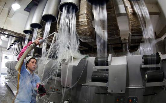 资料图:工人将烘干后的塑料碎片加工成丝状。新华社发