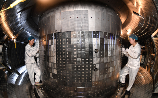 安徽合肥，科研人员在全超导托卡马克核聚变实验装置（EAST）真空室安装高场侧瓦片（资料图）