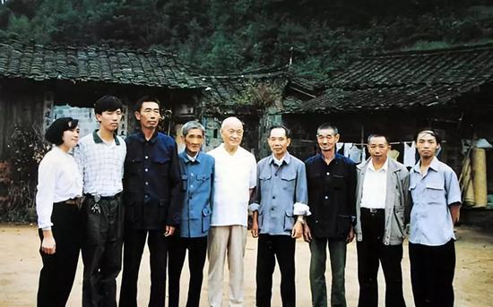 1986年5月,项南(中)在祖屋前与连城县朋口乡文地村的乡亲们在一起。