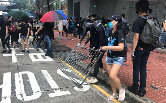 8月31日的非法集会中，有蒙面示威者拆卸道路两旁栏杆。