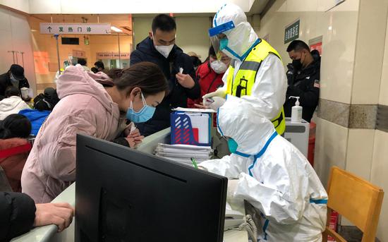 同济医院发热门诊内,“全副武装”的医护人员及戴着口罩的患者。新京报记者 向凯 摄