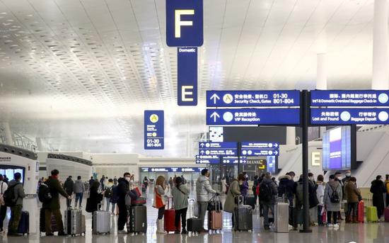1月23日，武汉天河国际机场，旅客们在人工柜台前排长队咨询退票与改签事项。图片/新京报拍者