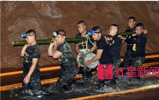 ▲泰國士兵扛着裝備進入洞穴 圖據《衛報》