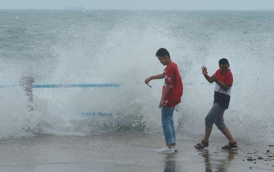 2018年8月19日，受台风“温比亚”影响，青岛市沿海一带掀起10几米高海浪，游客被海浪袭击。  东方IC 图