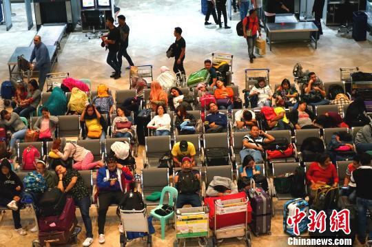17日夜,大量滞留旅客在马尼拉国际机场航站楼休息等候。 关向东 摄