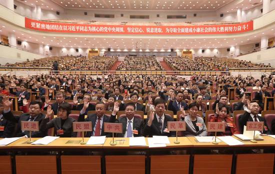 市政协委员举手表决通过。摄/新京报记者 王贵彬
