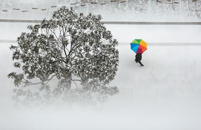 4日,山东省临沂市郯城县街头,一名行人在雪中行走。 张春雷摄(新华社发)