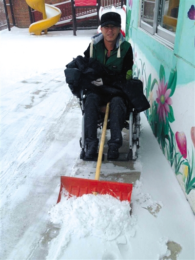 今年冬天，戴着假肢，坐着轮椅的宋学文在吉林老家扫雪。受访者供图