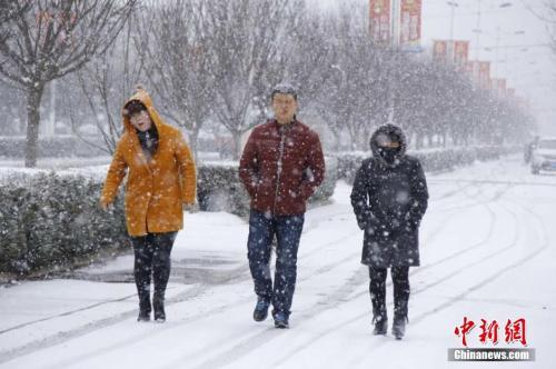 资料图:2016年3月9日,受强冷空气影响,甘肃多地出现降雪、降温天气。图为市民在雪中行走。 陈飞 摄