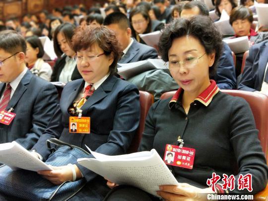 与会人员认真阅读政府工作报告。 赵桂华 摄