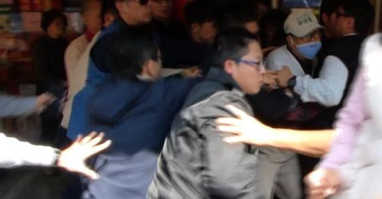 蔡英文遭戴口罩男子喊“下台”。这名男子随即被安保人员架走。